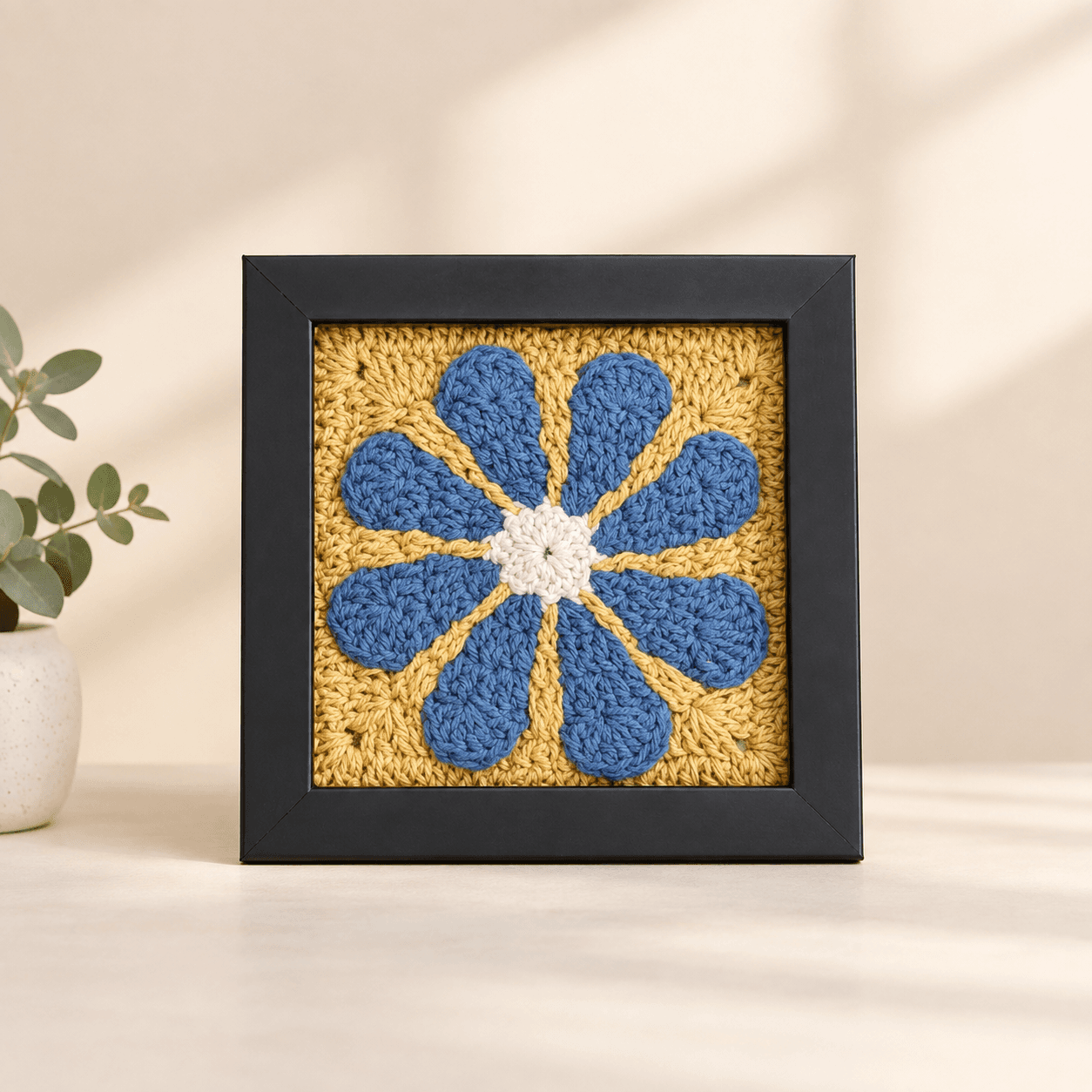 Blue daisy on mustard, dark frame