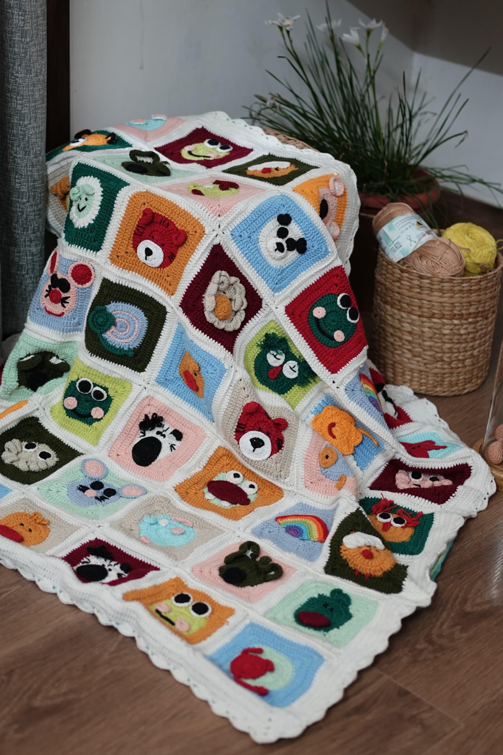 Bed Time Buddies granny-square crochet blanket with colorful animal faces and a cream scalloped border