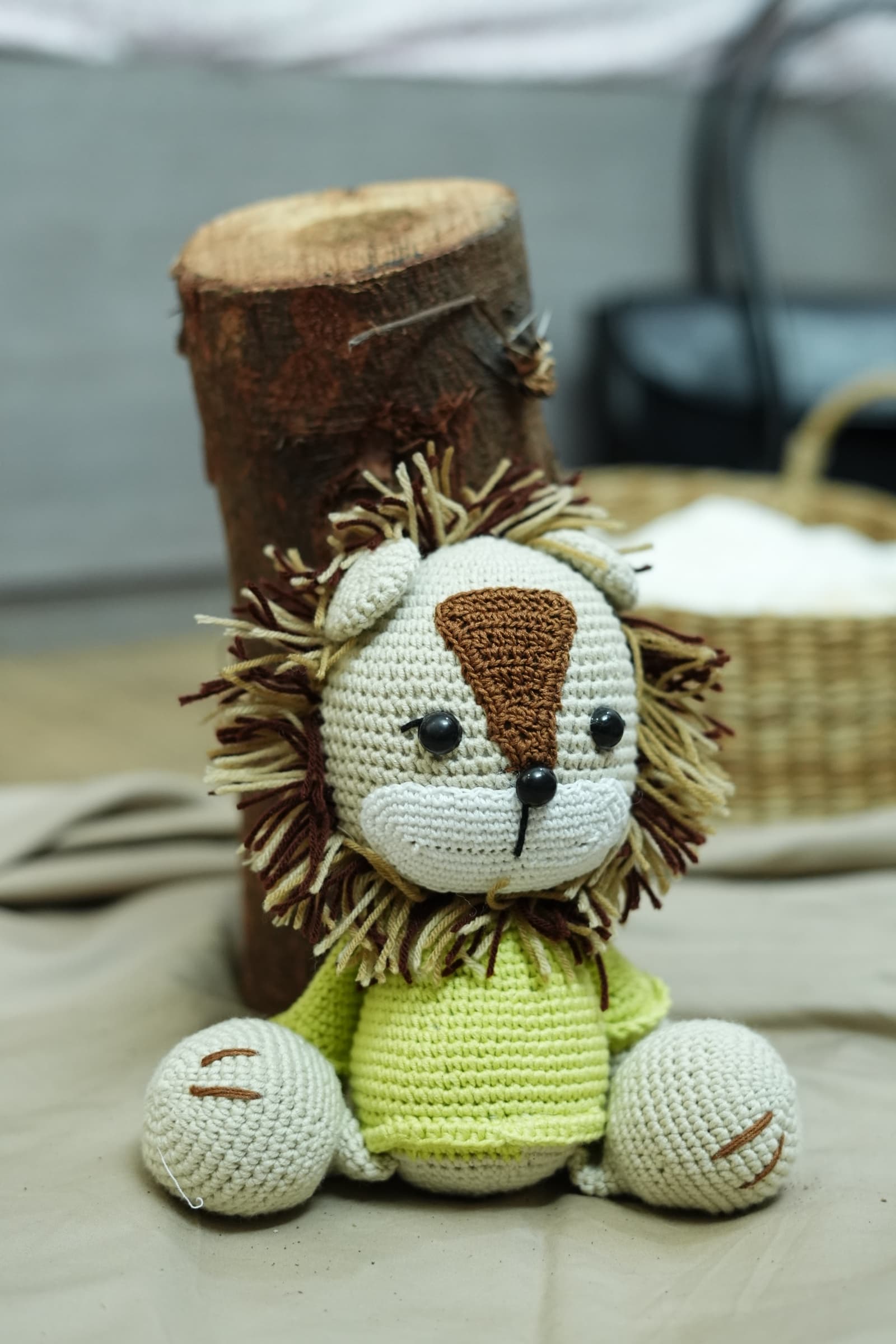 Crochet lion toy in a lime shirt