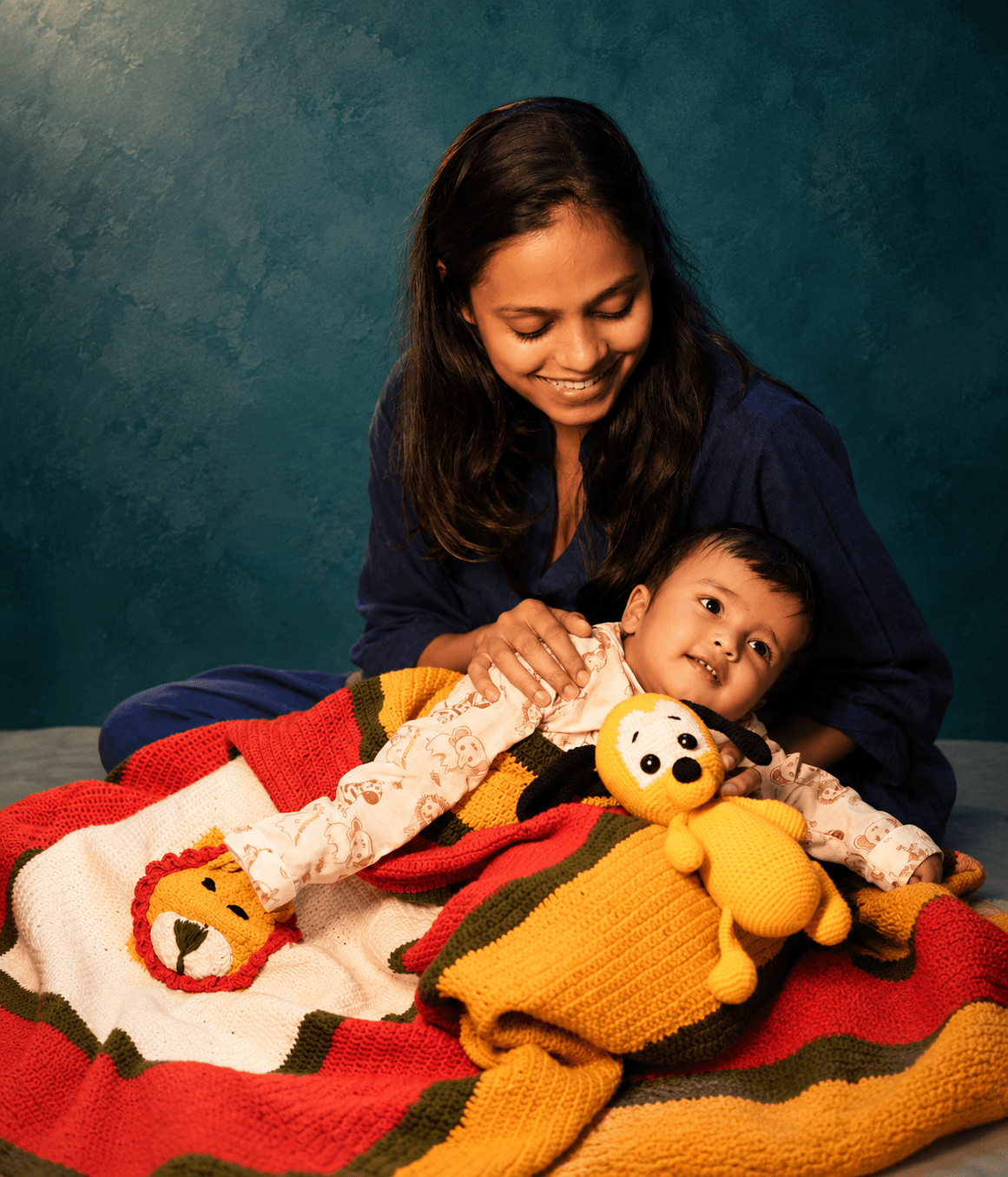 Mother and baby cuddled on a handmade crochet blanket